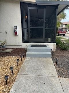 entrance to property featuring stucco siding