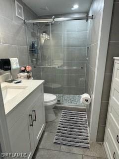 bathroom with vanity, tile walls, toilet, and a shower stall