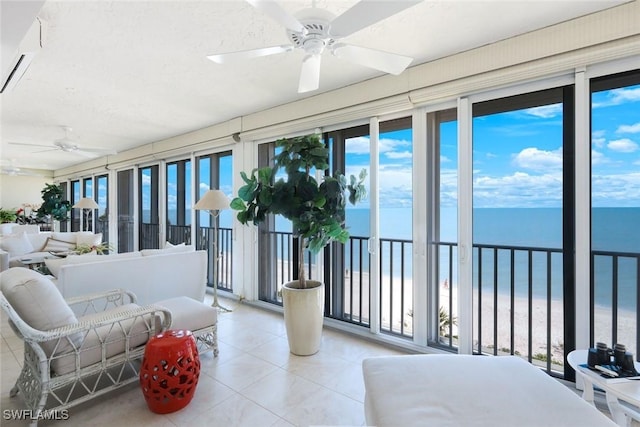 sunroom / solarium with a beach view, a water view, and ceiling fan