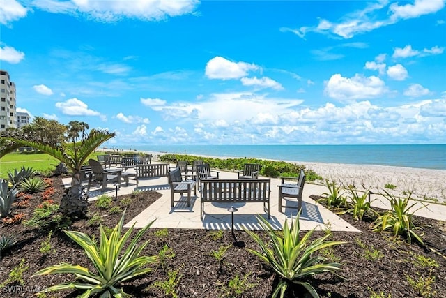 view of patio / terrace with a water view and a view of the beach