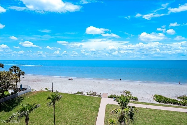 view of water feature featuring fence and a beach view