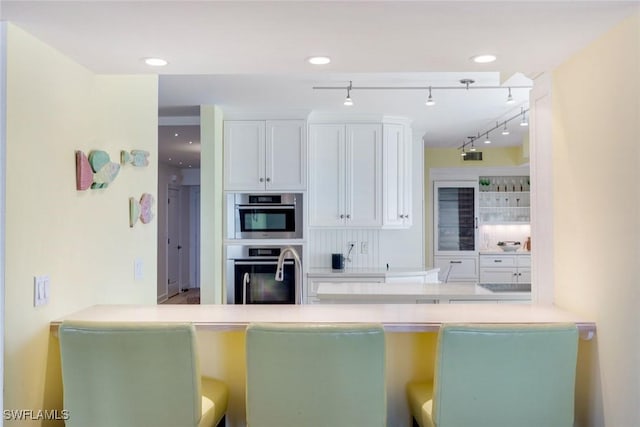 kitchen featuring white cabinetry, double oven, and recessed lighting