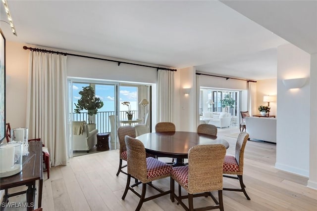 dining area featuring light wood finished floors and baseboards