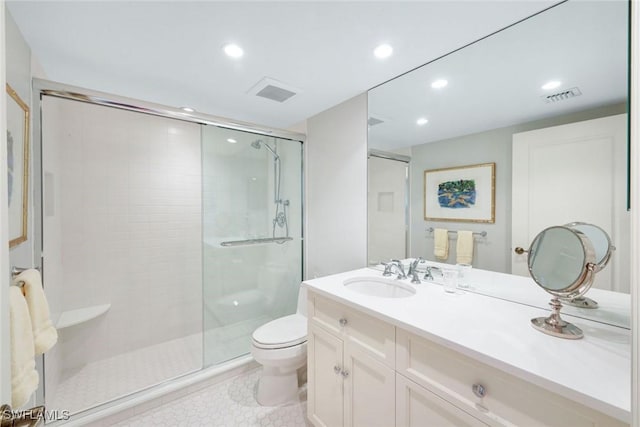 bathroom with visible vents, a shower stall, toilet, and vanity