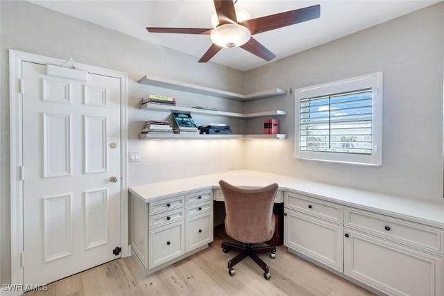 office area with light wood-style flooring, built in study area, and a ceiling fan