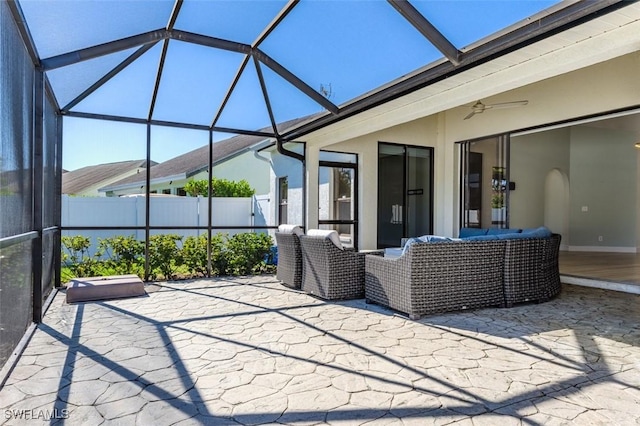 view of patio / terrace featuring a lanai, an outdoor living space, and fence