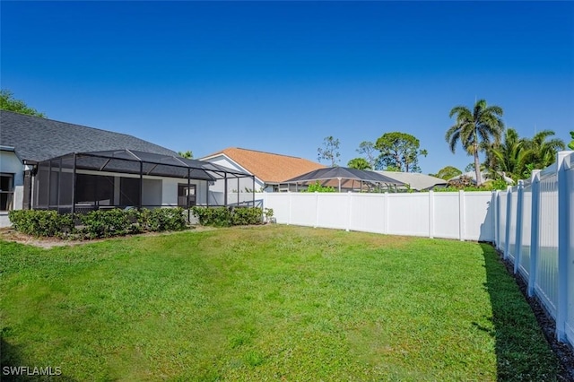view of yard featuring a lanai and a fenced backyard