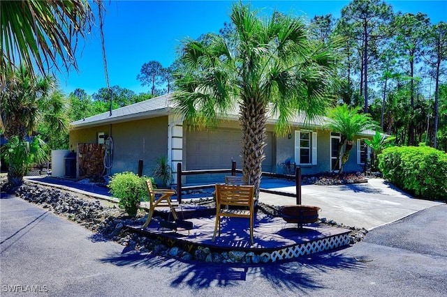 view of front of home featuring stucco siding, an attached garage, and driveway