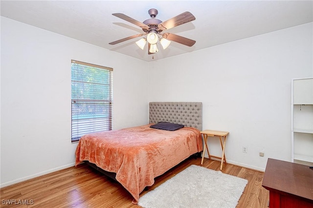 bedroom with baseboards, a ceiling fan, and light wood finished floors