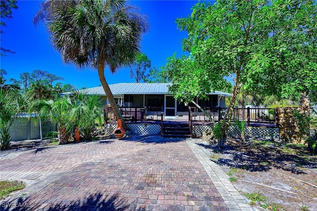 view of front of house with a wooden deck and metal roof