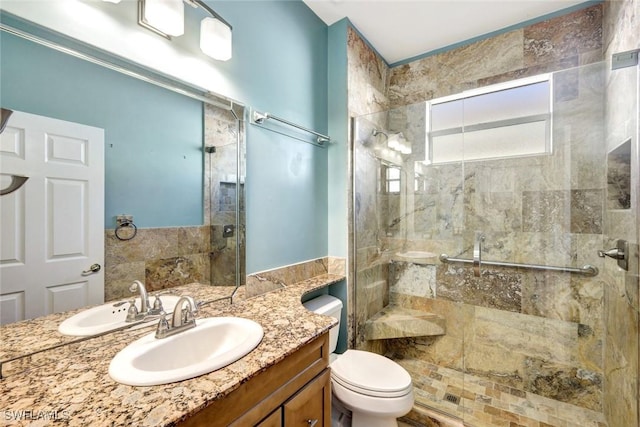 bathroom featuring a tile shower, toilet, and vanity