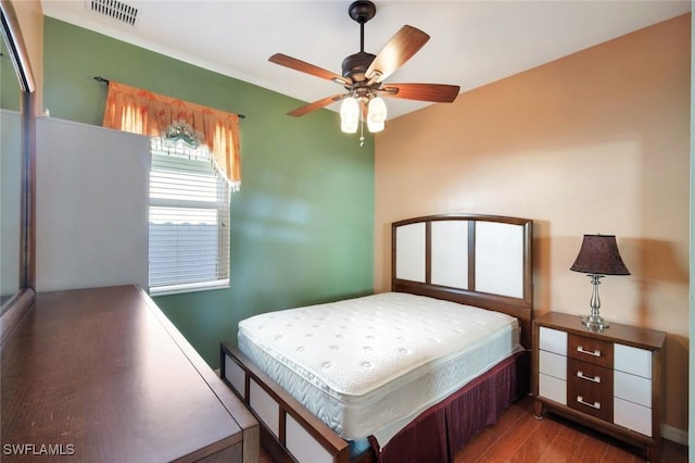 bedroom featuring a ceiling fan, wood finished floors, and visible vents