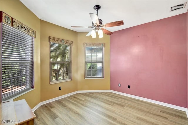 unfurnished room with visible vents, baseboards, a ceiling fan, and wood finished floors