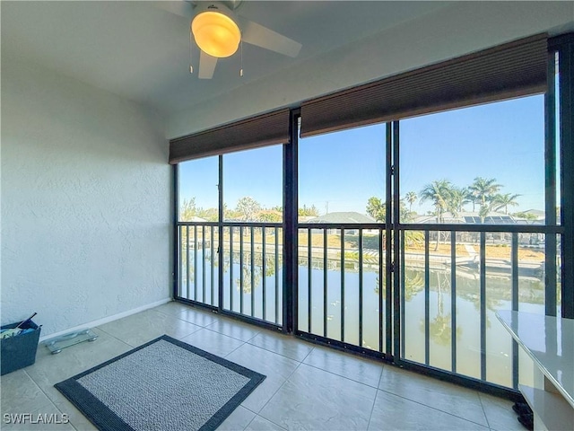 sunroom featuring a water view