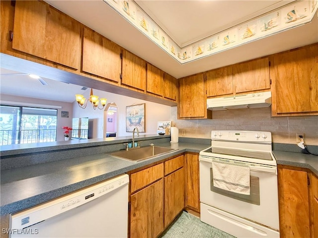 kitchen with under cabinet range hood, white appliances, brown cabinetry, and a sink