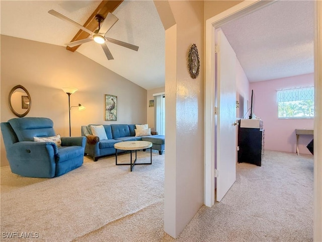 living room with vaulted ceiling with beams, ceiling fan, carpet floors, arched walkways, and a textured ceiling