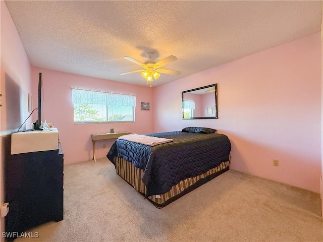 bedroom with light carpet, a textured ceiling, and a ceiling fan