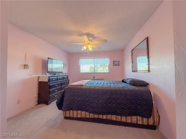 bedroom with light colored carpet, a textured ceiling, and a ceiling fan