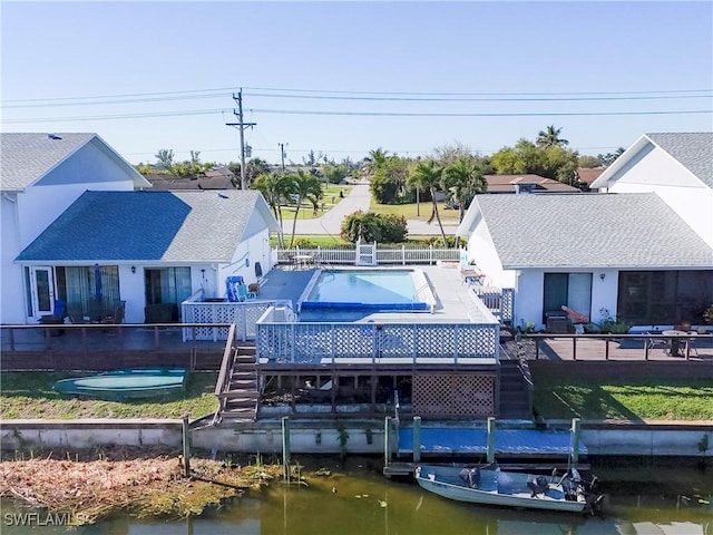 rear view of house featuring a fenced backyard, a deck with water view, a fenced in pool, stairs, and a patio area