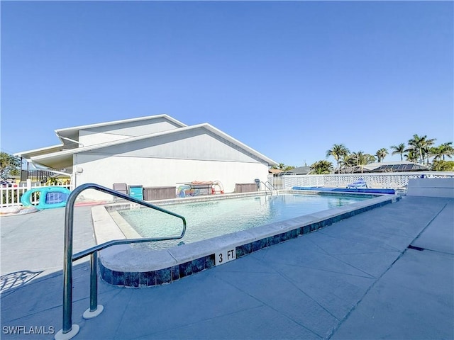 pool with a patio and a fenced backyard