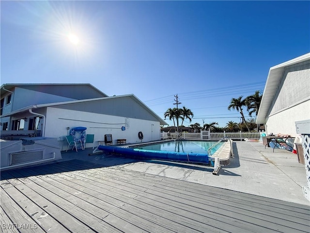 pool featuring a wooden deck and fence