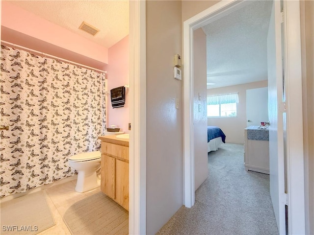 bathroom featuring visible vents, connected bathroom, toilet, vanity, and a textured ceiling