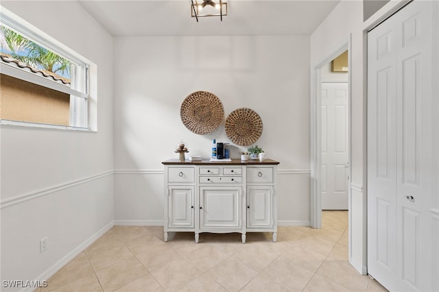 corridor featuring light tile patterned floors and baseboards