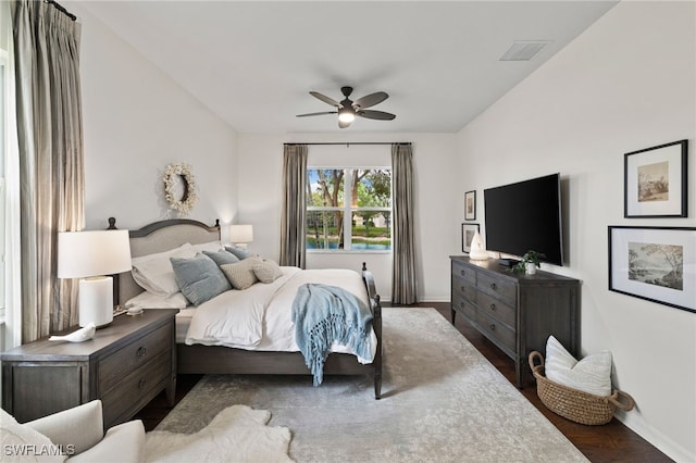 bedroom featuring visible vents, baseboards, wood finished floors, and a ceiling fan