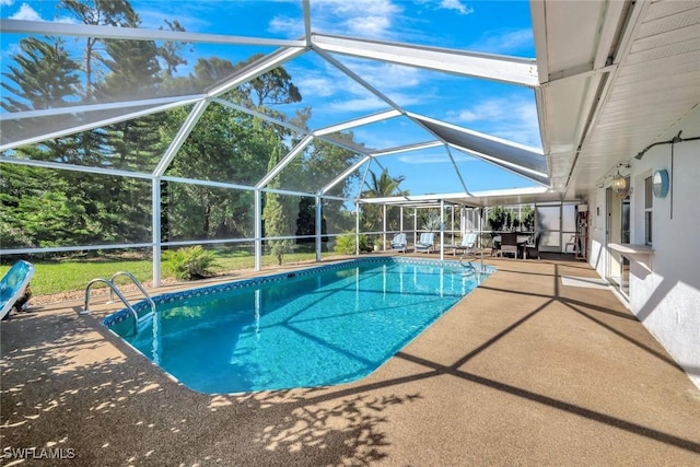 outdoor pool with glass enclosure and a patio area