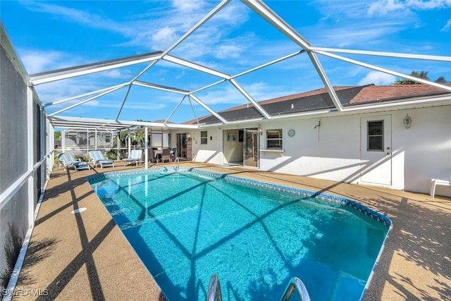 pool with glass enclosure and a patio area