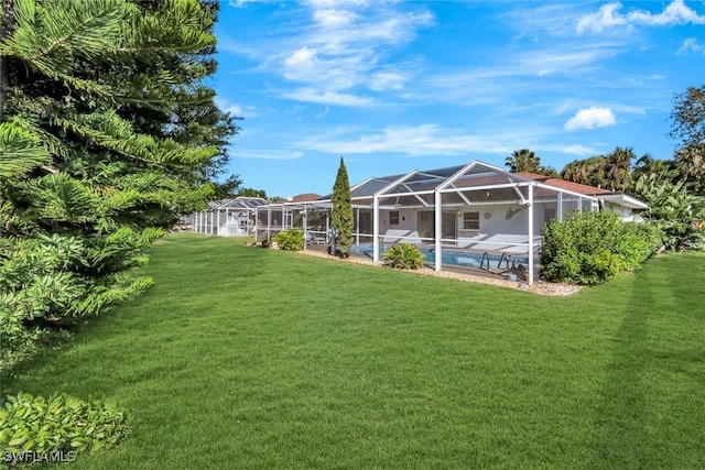 view of yard with an outdoor pool and a lanai