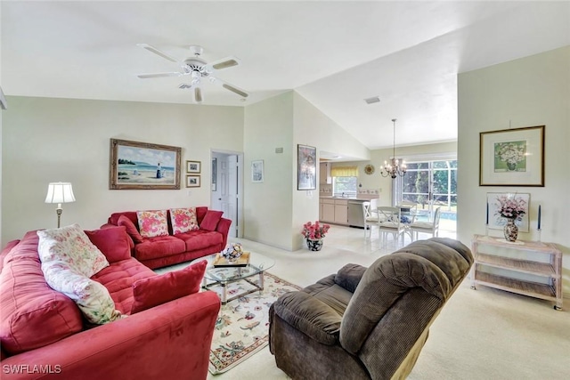 living area featuring ceiling fan with notable chandelier, carpet floors, and vaulted ceiling