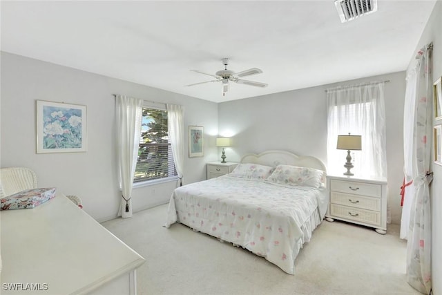 bedroom featuring multiple windows, light colored carpet, and visible vents