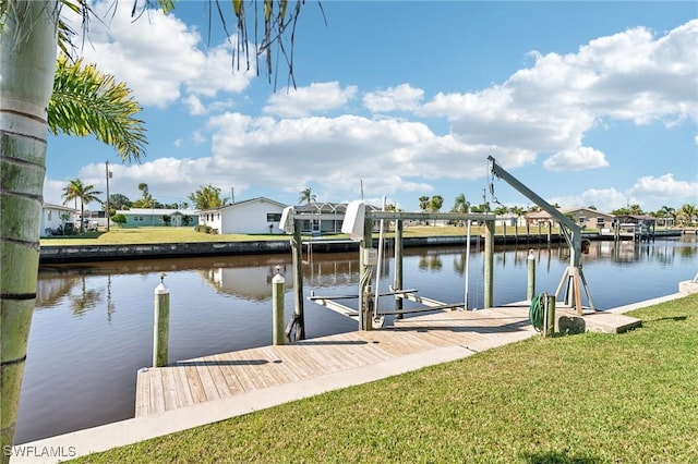 dock area with boat lift, a residential view, a yard, and a water view