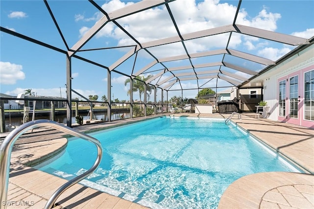 pool with a patio area, french doors, a lanai, and a water view