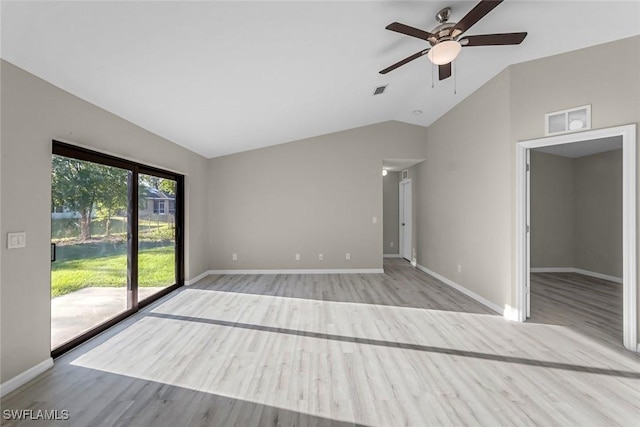 unfurnished room with visible vents, baseboards, lofted ceiling, and wood finished floors