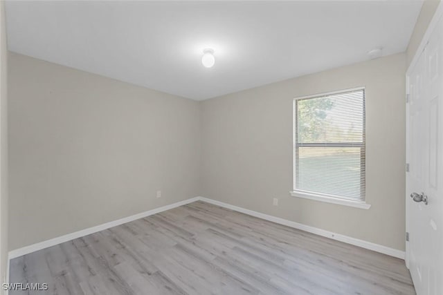 spare room featuring wood finished floors and baseboards