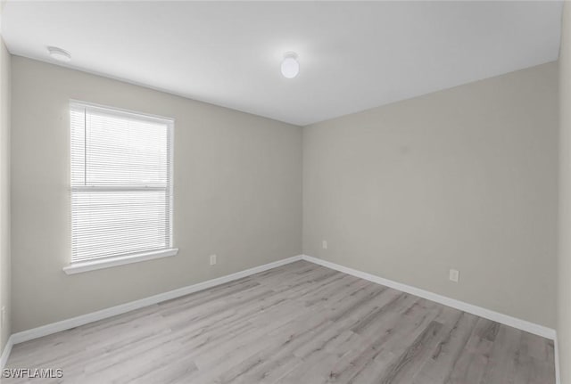 spare room featuring wood finished floors and baseboards