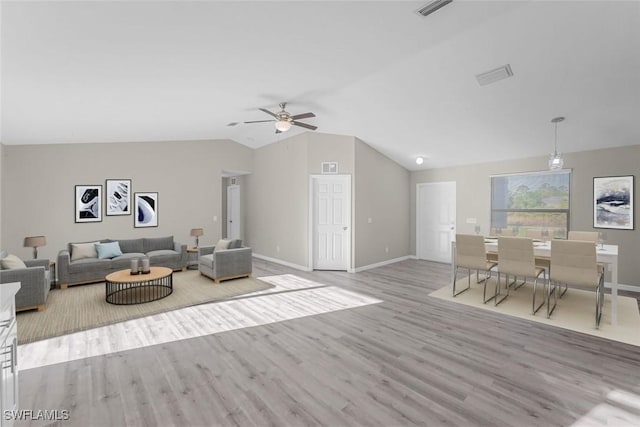 living room with lofted ceiling, wood finished floors, visible vents, and ceiling fan