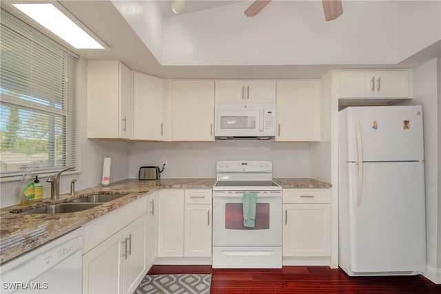 kitchen featuring a sink, light stone counters, white cabinets, white appliances, and dark wood-style flooring