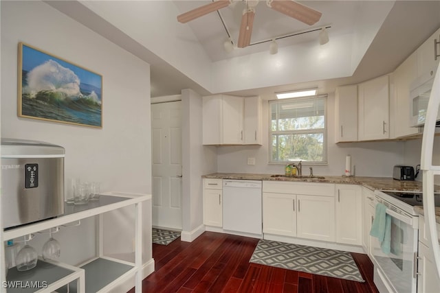 kitchen with light stone counters, a sink, dark wood finished floors, white appliances, and ceiling fan