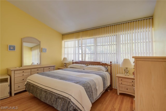 bedroom with lofted ceiling and light wood-type flooring