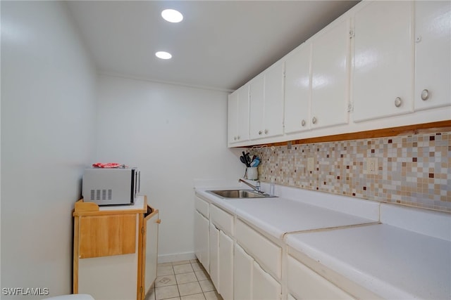 laundry room featuring light tile patterned floors, recessed lighting, and a sink