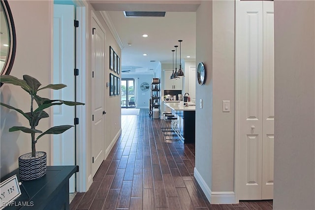 corridor with recessed lighting, baseboards, ornamental molding, and wood tiled floor