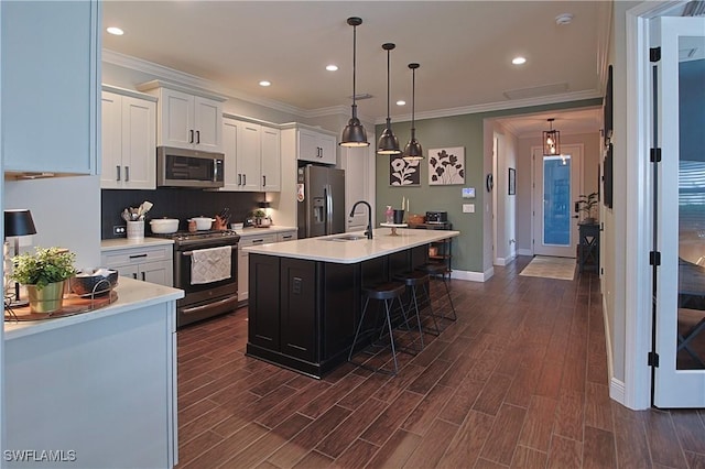 kitchen featuring dark wood-style floors, appliances with stainless steel finishes, white cabinetry, and light countertops