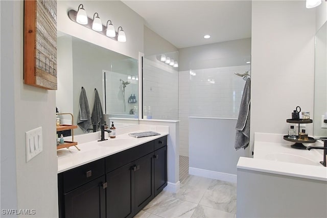 bathroom with marble finish floor, two vanities, a sink, recessed lighting, and walk in shower