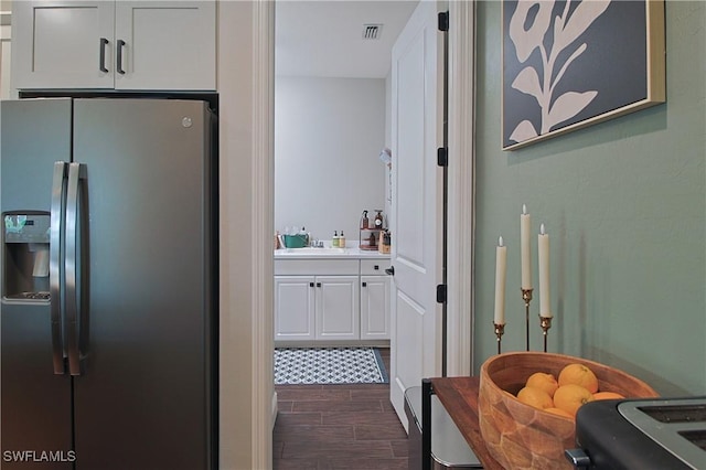 interior space featuring wood finish floors, visible vents, and a sink