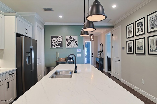 kitchen with visible vents, a sink, crown molding, black fridge with ice dispenser, and dark wood-style flooring