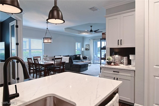 kitchen with crown molding, a healthy amount of sunlight, visible vents, and pendant lighting