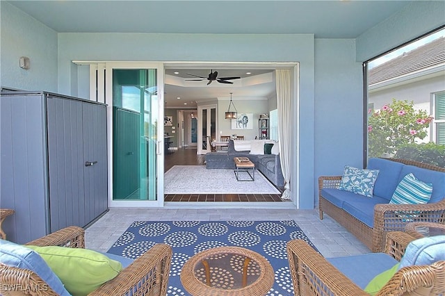 exterior space featuring tile patterned flooring, recessed lighting, a ceiling fan, and a tray ceiling